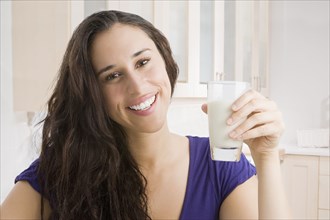 Mixed race woman drinking milk