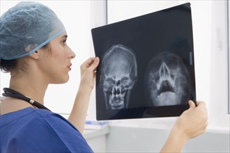 Mixed race surgeon reviewing x-rays