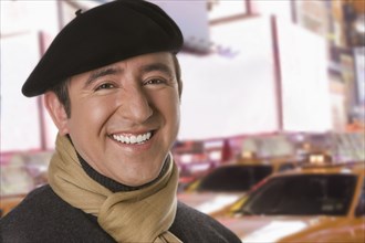 Hispanic man in beret on city street