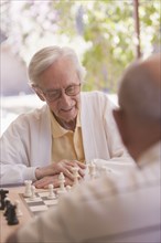 Senior men playing chess outdoors