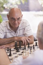 Senior men playing chess outdoors