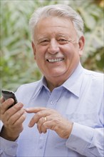 Senior Chilean man using cell phone