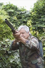 Senior Chilean man pointing shotgun