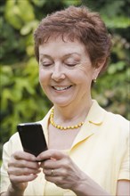 Senior Chilean woman text messaging on cell phone
