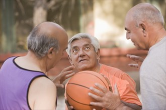 Senior Chilean men playing basketball together