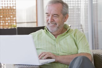 Senior Chilean man typing on laptop