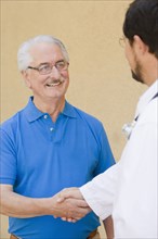 Senior man shaking hands with doctor