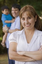 Smiling Hispanic woman outdoors with family