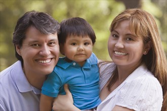 Smiling Hispanic parents holding baby boy