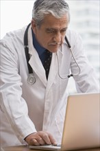 Hispanic doctor using laptop