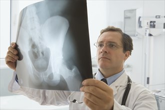Caucasian doctor looking at hip x-ray