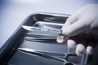 Close up of Hispanic doctor holding surgical equipment