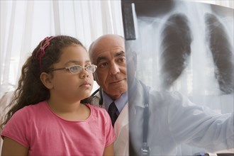 Hispanic doctor showing chest x-rays to patient