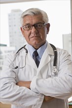 Hispanic doctor standing with arms crossed