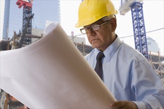 Hispanic businessman reading blueprints