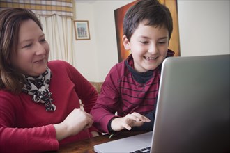 Hispanic mother and son using laptop together