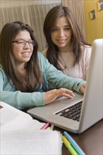 Hispanic mother and daughter using laptop