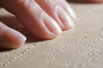 Close up of Hispanic woman reading Braille