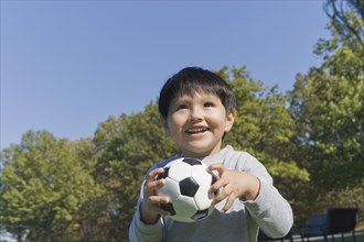 Hispanic boy playing soccer outdoors