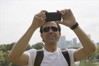 Hispanic man using camera phone