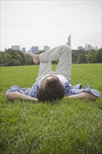 Hispanic man laying in grass at park