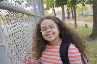 Portrait of Hispanic school girl at fence