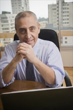 Portrait of confident Hispanic businessman in urban office