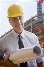 Portrait of smiling Hispanic architect at construction site