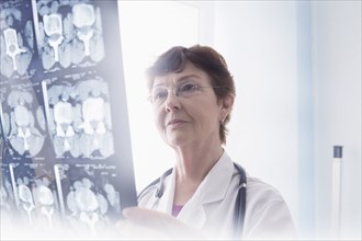 Hispanic doctor examining x-rays in office