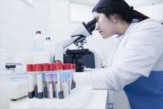 Hispanic scientist examining blood samples in laboratory