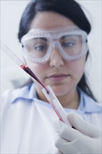 Hispanic scientist pipetting blood sample