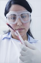Hispanic scientist pipetting blood sample