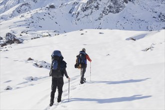Hispanic hikers walking on snowy mountain