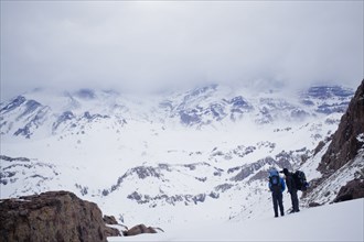 Hispanic hikers admiring snowy scenic mountains