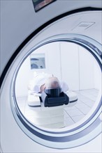 Older Hispanic man laying in MRI scanner