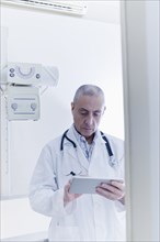 Hispanic doctor using digital tablet in hospital