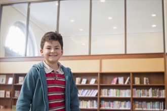 Hispanic boy smiling in library