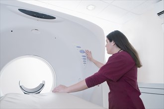 Hispanic doctor operating MRI machine