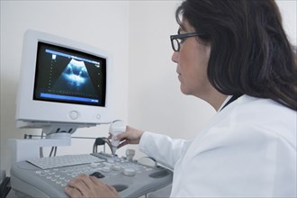 Hispanic doctor examining sonogram in hospital