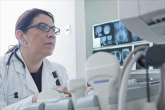 Hispanic doctor using machinery in hospital