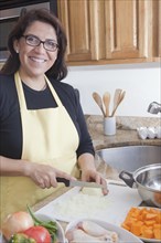 Hispanic woman cooking in kitchen