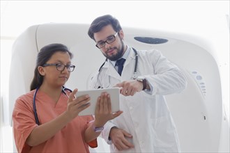 Hispanic doctor and nurse using digital tablet