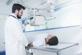 Hispanic doctor comforting patient at x-ray machine