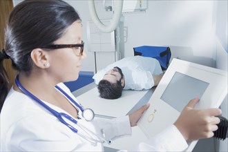 Hispanic doctor at control panel of x-ray machine