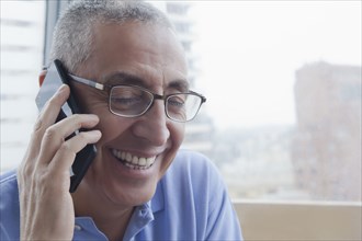 Smiling Hispanic man talking on cell phone