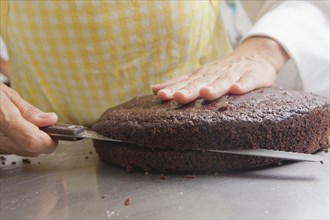 Hispanic woman cutting cake with knife