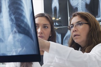 Hispanic doctors examining x-ray of chest