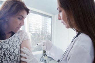 Hispanic doctor vaccinating patient