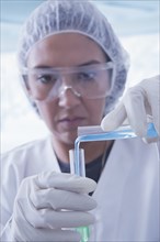 Hispanic scientist pouring liquid into test tube