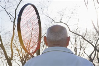 Rear view of Hispanic man holding tennis racket